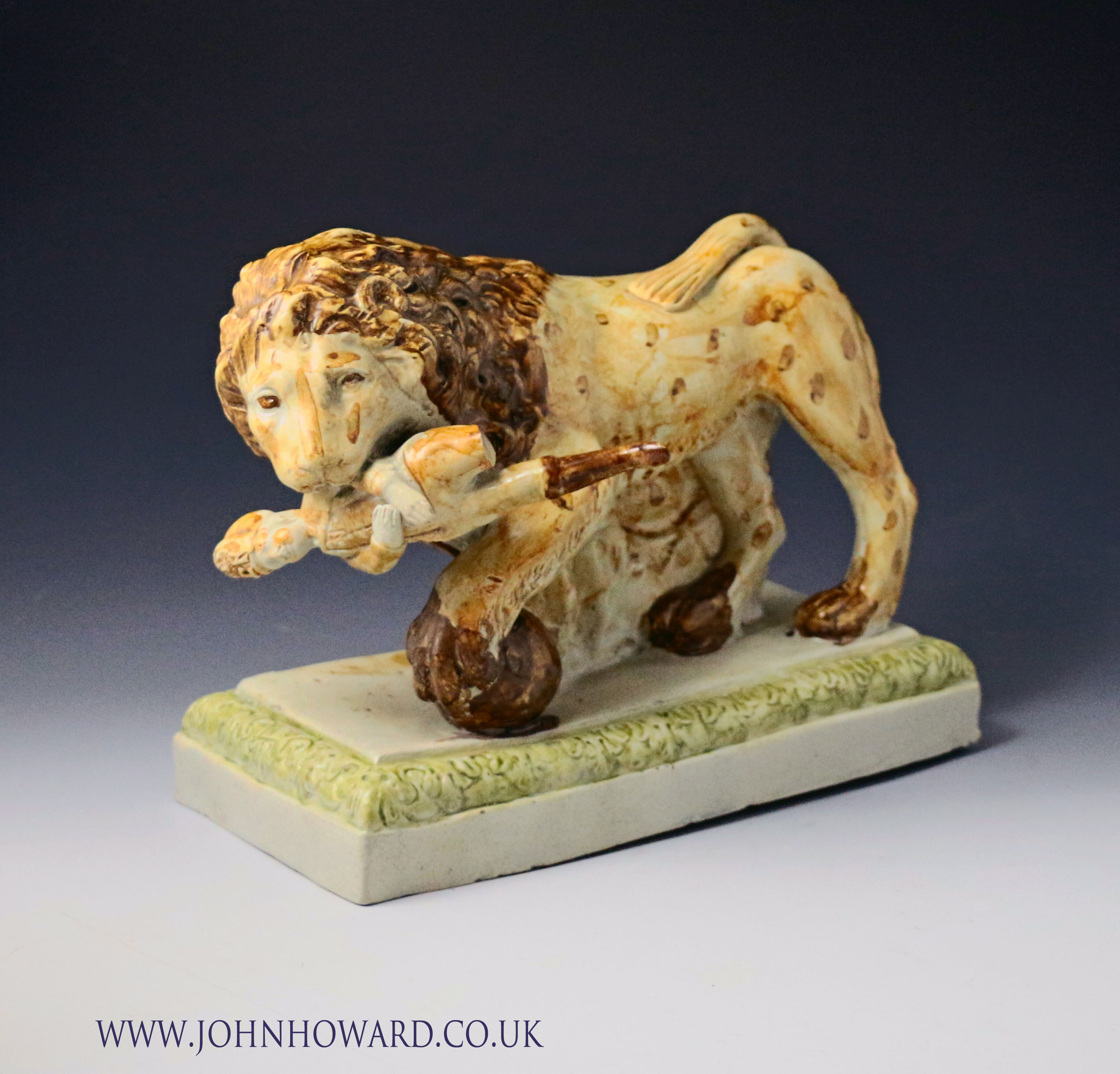 Antique Staffordshire pottery figure of a lion  an English soldier in his jaws late 18th century